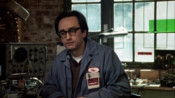 Movie still from “The Conversation” (1974), directed by Francis Ford Coppola – A man with glasses is sitting at a table; Medium shot, Low angle