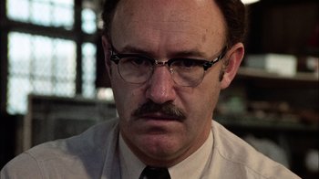 Movie still from “The Conversation” (1974), directed by Francis Ford Coppola – A person wearing glasses and a tie; Close Up shot, Low angle