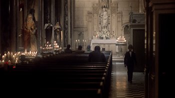 Movie still from “The Conversation” (1974), directed by Francis Ford Coppola – People are standing in a church with candles lit; Extreme Wide shot, High angle