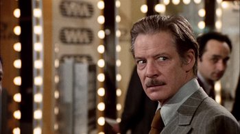 Movie still from “The Conversation” (1974), directed by Francis Ford Coppola – A person wearing a suit and tie; Close Up shot, Over the shoulder angle