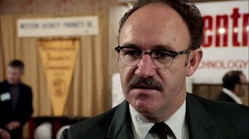 Movie still from “The Conversation” (1974), directed by Francis Ford Coppola – A man with a mustache wearing glasses and a suit; Close Up shot, Low angle