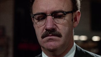 Movie still from “The Conversation” (1974), directed by Francis Ford Coppola – A person wearing glasses and a suit; Close Up shot, Low angle