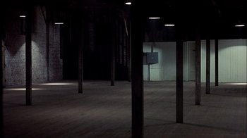 Movie still from “The Conversation” (1974), directed by Francis Ford Coppola – An empty room with a television on the wall; Extreme Wide shot, High angle