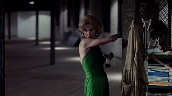 Movie still from “The Conversation” (1974), directed by Francis Ford Coppola – A woman in a green dress holding a cup in her hand; Medium shot, Over the shoulder angle