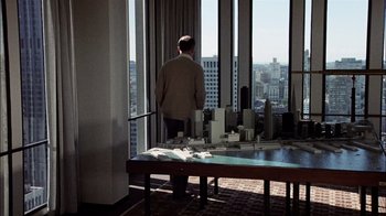 Movie still from “The Conversation” (1974), directed by Francis Ford Coppola – A man standing in front of a window looking out at a city; Extreme Wide shot, High angle