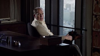 Movie still from “The Conversation” (1974), directed by Francis Ford Coppola – A man sitting at a desk in front of a window; Medium shot, Over the shoulder angle
