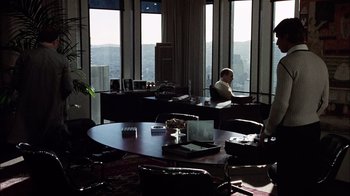 Movie still from “The Conversation” (1974), directed by Francis Ford Coppola – A man sitting at a table in front of a laptop; Extreme Wide shot, High angle