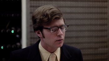 Movie still from “The Conversation” (1974), directed by Francis Ford Coppola – A man in a suit and tie wearing glasses; Close Up shot, Low angle
