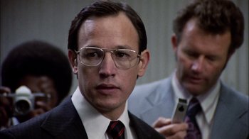 Movie still from “The Conversation” (1974), directed by Francis Ford Coppola – A person wearing a suit and glasses; Close Up shot, Low angle