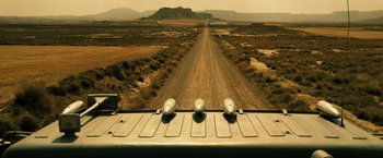 Movie still from “The Counselor” (2013), directed by Ridley Scott – A view of a dirt road from the back of a truck; Extreme Wide shot, High angle