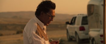 Movie still from “The Counselor” (2013), directed by Ridley Scott – A man in a white dress shirt holding a drink; Close Up shot, Over the shoulder angle