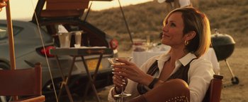 Movie still from “The Counselor” (2013), directed by Ridley Scott – A woman sitting at a table holding a wine glass; Close Up shot, Over the shoulder angle