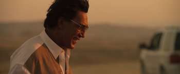 Movie still from “The Counselor” (2013), directed by Ridley Scott – A person wearing a suit and sunglasses; Close Up shot, Over the shoulder angle