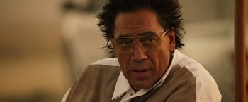 Movie still from “The Counselor” (2013), directed by Ridley Scott – A person wearing glasses and a jacket; Close Up shot, Low angle