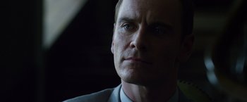 Movie still from “The Counselor” (2013), directed by Ridley Scott – A person wearing a suit and tie; Close Up shot, Low angle