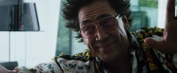 Movie still from “The Counselor” (2013), directed by Ridley Scott – A person wearing glasses and smiling; Close Up shot, Low angle
