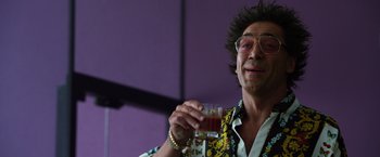 Movie still from “The Counselor” (2013), directed by Ridley Scott – A man in a hawaiian shirt holding a glass of juice; Close Up shot, Low angle
