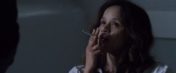 Movie still from “The Counselor” (2013), directed by Ridley Scott – A woman is smoking a cigarette in a dark room; Close Up shot, High angle