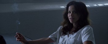 Movie still from “The Counselor” (2013), directed by Ridley Scott – A woman in white shirt holding a remote control; Close Up shot, High angle