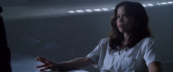 Movie still from “The Counselor” (2013), directed by Ridley Scott – A woman sitting at a table in front of a window; Medium shot, Low angle