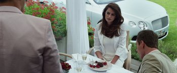 Movie still from “The Counselor” (2013), directed by Ridley Scott – A woman sitting at a table with a plate of cake; Medium shot, Over the shoulder angle