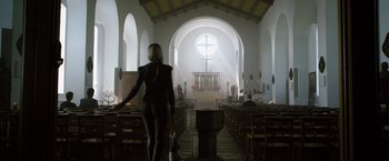 Movie still from “The Counselor” (2013), directed by Ridley Scott – A woman standing in front of a cross in a church; Wide shot, Low angle
