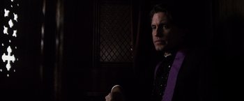 Movie still from “The Counselor” (2013), directed by Ridley Scott – A man wearing a purple shirt and a purple tie; Medium shot, Low angle