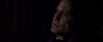 Movie still from “The Counselor” (2013), directed by Ridley Scott – A person wearing a suit and tie; Close Up shot, Low angle