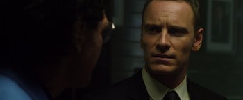 Movie still from “The Counselor” (2013), directed by Ridley Scott – A man in a suit and tie looking into a mirror; Close Up shot, Over the shoulder angle