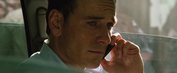 Movie still from “The Counselor” (2013), directed by Ridley Scott – A person talking on a cell phone; Close Up shot, Low angle