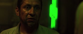 Movie still from “The Counselor” (2013), directed by Ridley Scott – A person's face in front of a green light; Close Up shot, Low angle