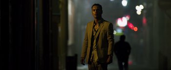 Movie still from “The Counselor” (2013), directed by Ridley Scott – A man in a suit standing in the dark; Medium shot, Low angle