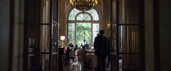 Movie still from “The Counselor” (2013), directed by Ridley Scott – People are sitting at tables in an elegant restaurant; Wide shot, Over the shoulder angle