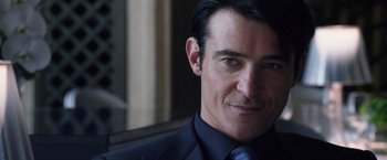 Movie still from “The Counselor” (2013), directed by Ridley Scott – A person wearing a suit and tie; Close Up shot, Over the shoulder angle