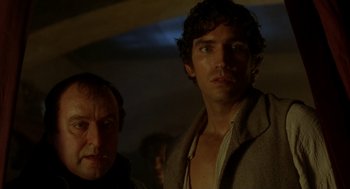 Movie still from “The Count of Monte Cristo” (2002), directed by Kevin Reynolds – A man standing next to another man in a dark room; Close Up shot, Low angle