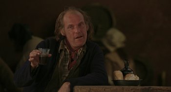 Movie still from “The Count of Monte Cristo” (2002), directed by Kevin Reynolds – An older man sitting at a table with a glass of wine; Close Up shot, Over the shoulder angle