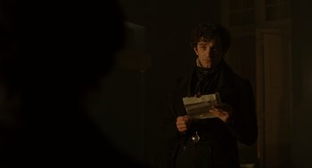 Movie still from “The Count of Monte Cristo” (2002), directed by Kevin Reynolds – A man standing in a dark room holding a piece of paper; Medium shot, Over the shoulder angle