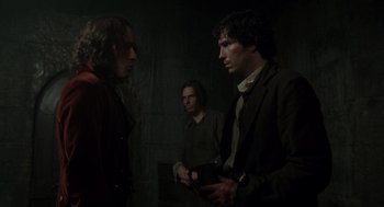 Movie still from “The Count of Monte Cristo” (2002), directed by Kevin Reynolds – A group of men standing next to each other in a dark room; Medium shot, Over the shoulder angle