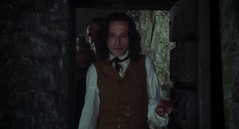Movie still from “The Count of Monte Cristo” (2002), directed by Kevin Reynolds – A man with long hair wearing a vest and a tie; Medium shot, Over the shoulder angle