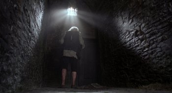 Movie still from “The Count of Monte Cristo” (2002), directed by Kevin Reynolds – A person in a dark room with light shining through the window; Wide shot, Low angle