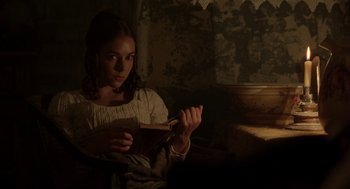 Movie still from “The Count of Monte Cristo” (2002), directed by Kevin Reynolds – A young woman sitting in a chair reading a book; Medium shot, Over the shoulder angle