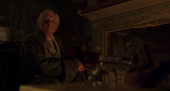 Movie still from “The Count of Monte Cristo” (2002), directed by Kevin Reynolds – An older man sitting in front of a fire place; Medium shot, Over the shoulder angle