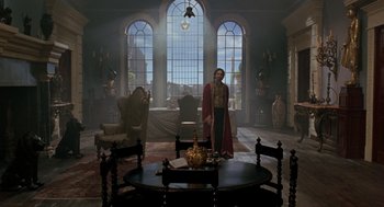 Movie still from “The Count of Monte Cristo” (2002), directed by Kevin Reynolds – A man standing in front of a table in a living room; Wide shot, Low angle
