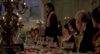 Movie still from “The Count of Monte Cristo” (2002), directed by Kevin Reynolds – A group of people sitting at a long table with wine glasses on it; Medium shot, Over the shoulder angle