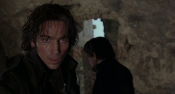 Movie still from “The Count of Monte Cristo” (2002), directed by Kevin Reynolds – A man standing next to another man in a dark room; Close Up shot, Over the shoulder angle