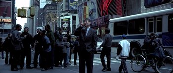 Movie still from “Phone Booth” (2002), directed by Joel Schumacher – A man standing on a busy city street talking on a cell phone; Wide shot, Low angle