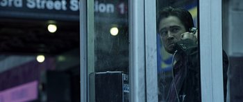 Movie still from “Phone Booth” (2002), directed by Joel Schumacher – A man looking out of a train window at a train station; Medium shot, Low angle