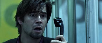 Movie still from “Phone Booth” (2002), directed by Joel Schumacher – A person holding a phone up to their ear; Close Up shot, Low angle