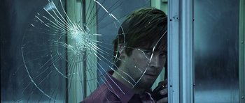 Movie still from “Phone Booth” (2002), directed by Joel Schumacher – A man is looking through a shattered window; Close Up shot, Low angle