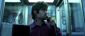 Movie still from “Phone Booth” (2002), directed by Joel Schumacher – A young man with a bloody ear on a phone; Close Up shot, Low angle